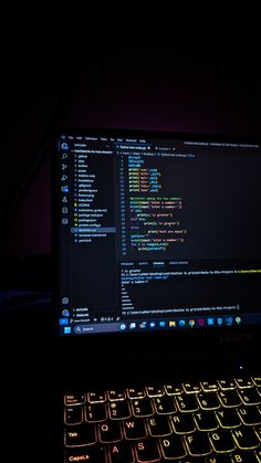 an open laptop computer sitting on top of a dark table next to a neon lit keyboard