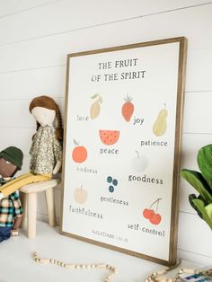 the fruit of the spirit is displayed in front of a framed poster on a shelf