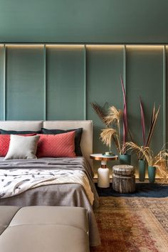 a large bed sitting next to a wooden table with two planters on top of it