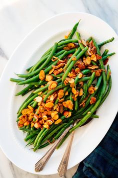 a white plate topped with green beans and almonds