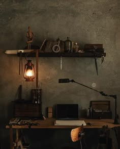 a wooden desk topped with a laptop computer next to a wall mounted shelf filled with books