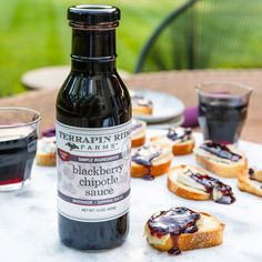 a bottle of blackberry chute sauce sitting on top of a table next to slices of bread