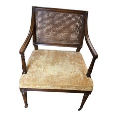 a wooden chair with cane back and seat cushion on it's armrests