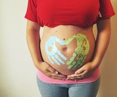 a pregnant woman with her hands painted on her stomach