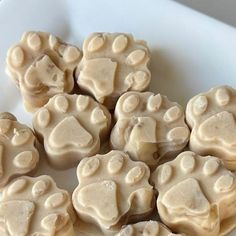 a white plate topped with cookies covered in frosting and paw prints on top of it