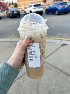 a person holding up a cup of coffee