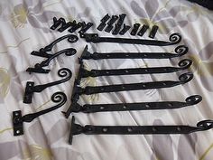 six pairs of black iron door handles on a bed