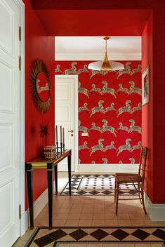 the hallway is painted bright red and decorated with wallpaper