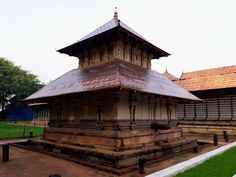 an old wooden structure in the middle of a park