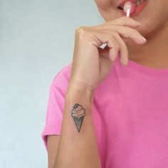 a woman with a small ice cream cone tattoo on her left arm and right hand