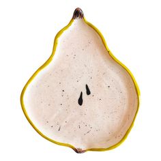 a white and yellow pear shaped dish with two black drops on the top, sitting in front of a white background