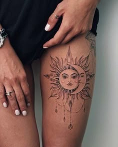 a woman's thigh with sun and moon tattoos on it, while holding onto her leg