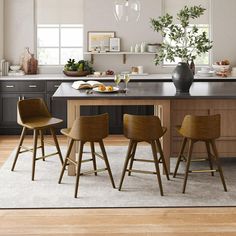 the kitchen is clean and ready to be used for dinner or breakfast time, while the dining table has been set up with four bar stools