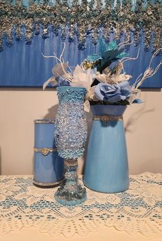 three blue vases sitting on top of a table