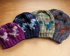 three knitted hats sitting on top of a wooden table