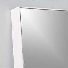 a bathroom mirror mounted to the side of a wall