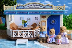 two teddy bears are standing in front of a doll house