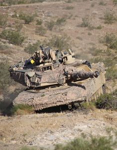 an army tank is moving through the desert