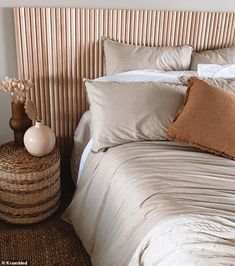 a bed with white sheets and brown pillows