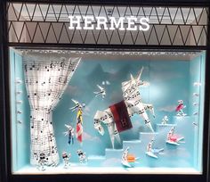 a display case with musical instruments and horses in the window for hermes'new store