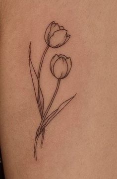 a black and white photo of a flower on the back of a woman's shoulder