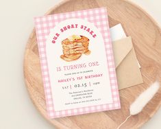 a pink and white birthday card with a stack of pancakes on it next to a piece of paper