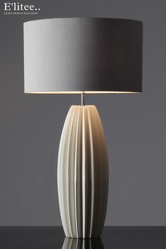 a lamp that is on top of a table with a black and white lampshade