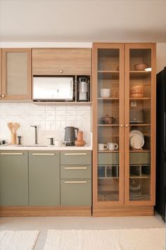 a kitchen with green cabinets and white walls