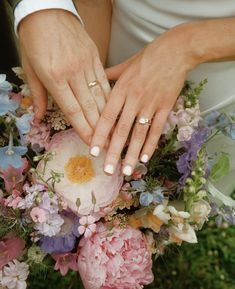 the bride and groom are holding hands with their wedding rings