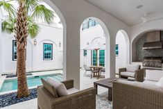 an outdoor living area with couches, chairs and a pool in front of it