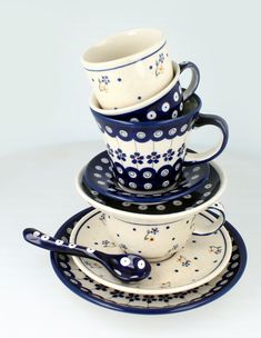 a stack of cups and saucers with spoons