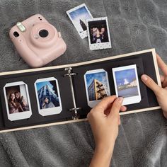 a person holding an open book with polaroid pictures on the pages and photos in it