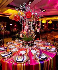 the table is set with plates, silverware and colorful centerpieces for an elegant dinner