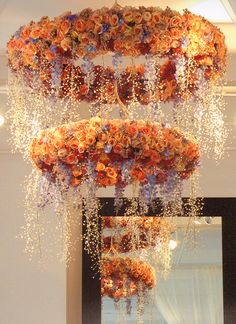 a chandelier made out of flowers hanging from the ceiling