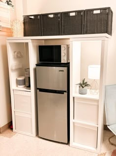 a refrigerator freezer sitting inside of a kitchen next to a shelf filled with baskets