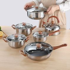 a woman is preparing pots and pans on a table