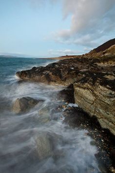 some rocks and water on the shore