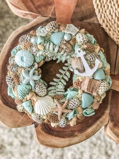 a wreath with seashells, shells and an anchor sits on a piece of wood