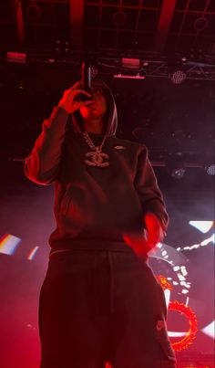 a man standing on top of a stage while holding a cell phone to his ear