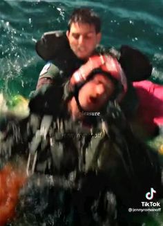 the man is being carried on a raft in the water by another person who is wearing a life jacket