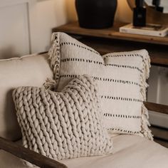 two pillows on a chair with a lamp in the background