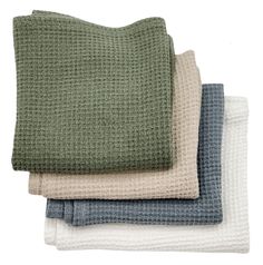 four blankets folded on top of each other in various colors and patterns, one is green