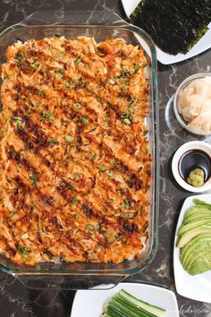 a casserole dish with vegetables and sauces on the side