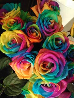 a bouquet of multicolored roses sitting on top of a table