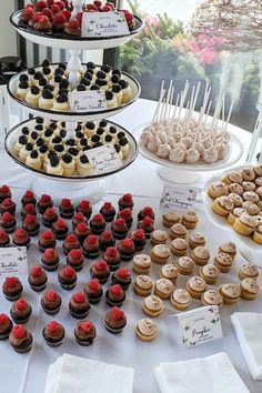 a table topped with lots of cupcakes next to other desserts and pastries