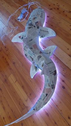 a paper mache shark is sitting on the floor