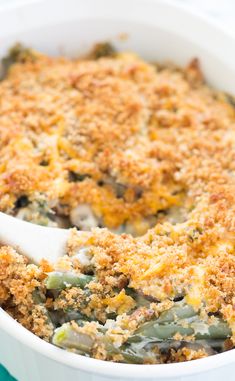 a casserole dish filled with green beans and potatoes, topped with crumbs