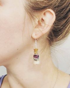 a close up of a person wearing some kind of earring with beads on it