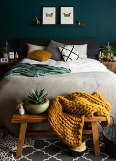 a bedroom with green walls and white bedding, pineapples on the end table