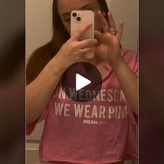 a woman taking a selfie in front of a mirror wearing a pink t - shirt